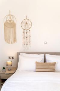 a bedroom with a bed with white sheets and chandeliers at In the heart of Fira & free pool - Nychteri suite in Fira