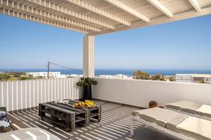 un patio con mesa y vistas al océano en In the heart of Fira & free pool - Nychteri suite en Fira