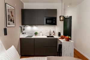 a kitchen with black cabinets and a white counter top at NUVA Apartments in Cologne
