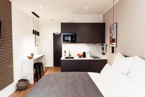 NUVA Apartments في كولونيا: غرفة نوم بسرير ومطبخ صغير