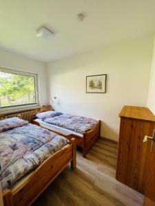 a bedroom with two beds and a window at Helles Ferienhaus Storchenblick in Buchholz Aller