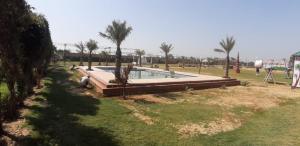 a swimming pool in a yard with palm trees at Elegance Resort in Jait