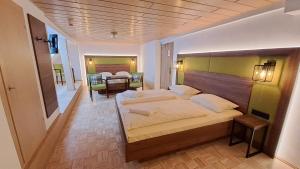 Schlafzimmer mit einem großen Bett mit einem Kopfteil aus Holz in der Unterkunft Hotel-Gasthof Goldener Greifen in Rothenburg ob der Tauber