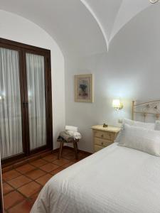 a bedroom with a bed and a table and a window at Casa Rural Mijarra **** in Herrera del Duque