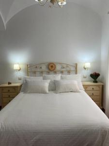 a bedroom with a white bed with two night stands at Casa Rural Mijarra **** in Herrera del Duque