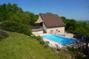a swimming pool in front of a house at Les Menoyres in Loubressac