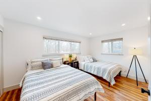 two beds in a room with white walls and wood floors at Donington Delight in Bella Vista