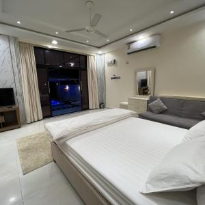 a large bedroom with a large bed and a couch at Estrahet Al Haitham in Al Qal‘ah
