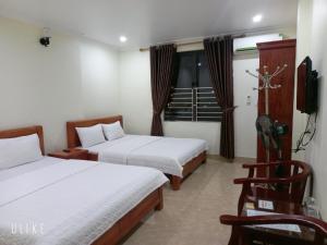 um quarto de hotel com duas camas e uma televisão em Guesthouse Anh Khang em Ha Long