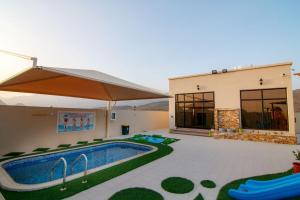 a house with a swimming pool next to a building at Estrahet Al Haitham in Al Qal‘ah