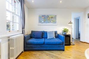 a blue couch sitting in a living room at Gorgeous Angel Flat in London