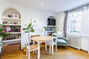 a dining room with a table and chairs and a window at Gorgeous Angel Flat in London