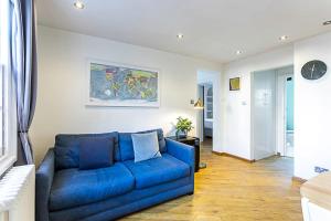 a blue couch sitting in a living room at Gorgeous Angel Flat in London