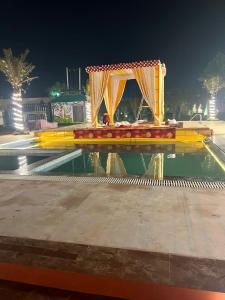 a stage in a pool of water at night at Elegance Resort in Jait +30 photos