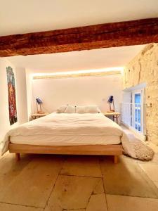ein Schlafzimmer mit einem großen Bett und zwei Tischen in der Unterkunft Le Yellow - Hôtel Particulier XIXème in Montpellier