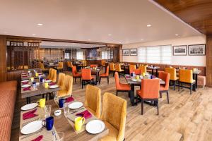 a dining room with tables and chairs in a restaurant at Fortune Resort Kalimpong- Member ITC's hotel group in Kalimpong