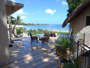 un patio con sedie, tavolo e vista sull'oceano di Beachfront Villa by M&H a Tamarin