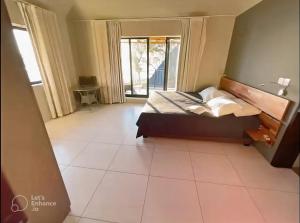 1 dormitorio con 1 cama y suelo de baldosa en Beachfront Villa by M&H en Tamarin