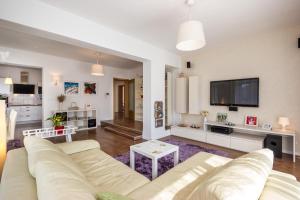 a living room with a white couch and a tv at Cozy and Modern Apartments in Kastav