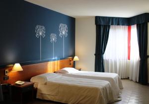 um quarto de hotel com duas camas e uma janela em DOMUS Grand Hotel em Rende