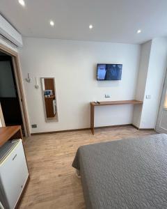 a bedroom with a bed and a tv on the wall at Wowies room in Pettenasco