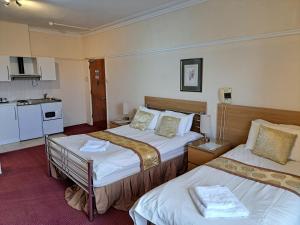 a hotel room with two beds and a kitchen at Diamond House in Rugby