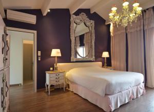 - une chambre avec un grand lit et un miroir dans l'établissement Logis Hôtel restaurant des Pins, à Bédoin