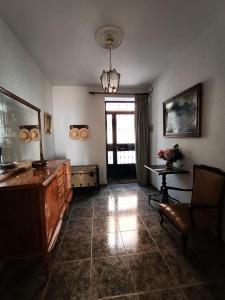 een woonkamer met een bank, een tafel en een kroonluchter bij Vivienda rural Los Iberos M&M in Castellar de Santisteban
