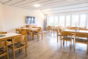 a dining room with tables and chairs and windows at Jugendherberge Kappeln in Kappeln
