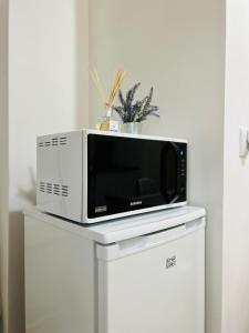 un horno microondas sentado en la parte superior de un armario blanco en AV Apartment, en Turda