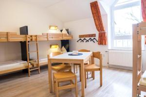 a room with a table and chairs and bunk beds at Jugendherberge Kappeln in Kappeln