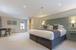 a large bedroom with a large bed and a desk at The Old Mill Inn in Dearham