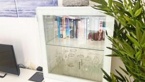 un armario de cristal con libros y gafas. en Grande appartamento Tenerife Los Abrigos, en Los Abrigos