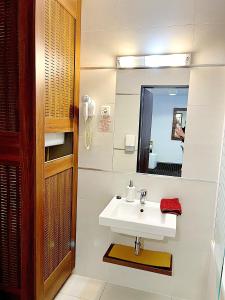 a bathroom with a sink and a mirror at Plage Brookforest Apartman in Hajdúszoboszló
