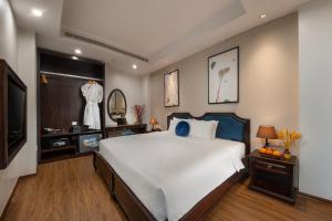 1 dormitorio con 1 cama blanca grande y TV en Hanoi Fiesta Grand Hotel and Spa, en Hanói