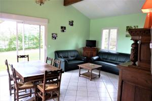 ein Wohnzimmer mit einem Tisch und einem Sofa in der Unterkunft La Balme in Loubressac