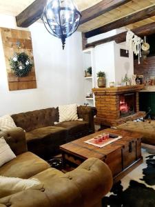 a living room with a couch and a coffee table at Čarovná chata pri potoku s krbom v interiéri in Štôla