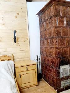 a bedroom with a large wooden wall next to a bed at Čarovná chata pri potoku s krbom v interiéri in Lazy pod Makytou