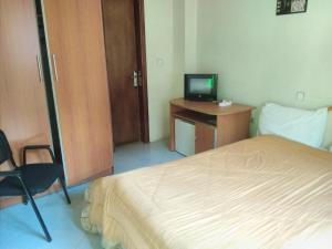 1 dormitorio con 1 cama y escritorio con TV en Wib Guesthouse en Addis Abeba