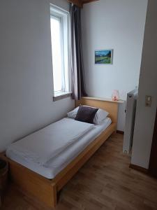 a bed in a bedroom with a window at Gästehaus Ferienglück Grainau in Grainau