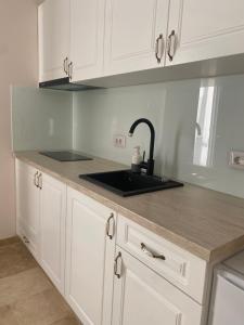 a kitchen with white cabinets and a sink at Apartament Timisoara 4 in Timişoara