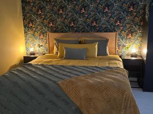 una camera da letto con un grande letto e carta da parati floreale di B&B Casa Oceo - Málaga - Andalusië ad Alhaurín de la Torre