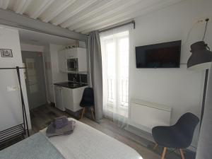 ein Wohnzimmer mit einem Bett und einem TV an der Wand in der Unterkunft Estudio con encanto en Casco Antiguo de Burgos P2 in Burgos
