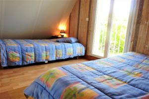 a bedroom with two beds and a window at La Balme in Loubressac