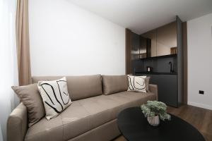 uma sala de estar com um sofá e uma mesa em Nest Apartments Sarajevo em Sarajevo