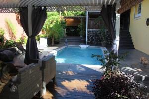 - une piscine dans une cour avec une terrasse dans l'établissement Le Rubinjo - Appartement d'hôtes, à Saint-Benoît