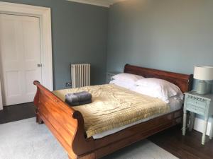 a bedroom with a wooden bed with white pillows at Collingwood House Tynemouth in Tynemouth