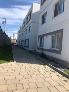 a brick sidewalk next to a white building at mumcular apartment in Bodrum City