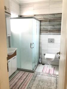 ein Bad mit einer Dusche, einem Waschbecken und einem WC in der Unterkunft mumcular apartment in Bodrum City