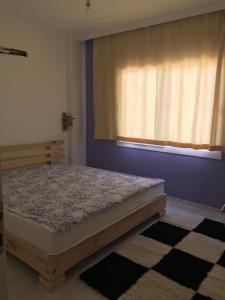Una cama en una habitación con ventana y un matadero. en mumcular apartment, en Bodrum City